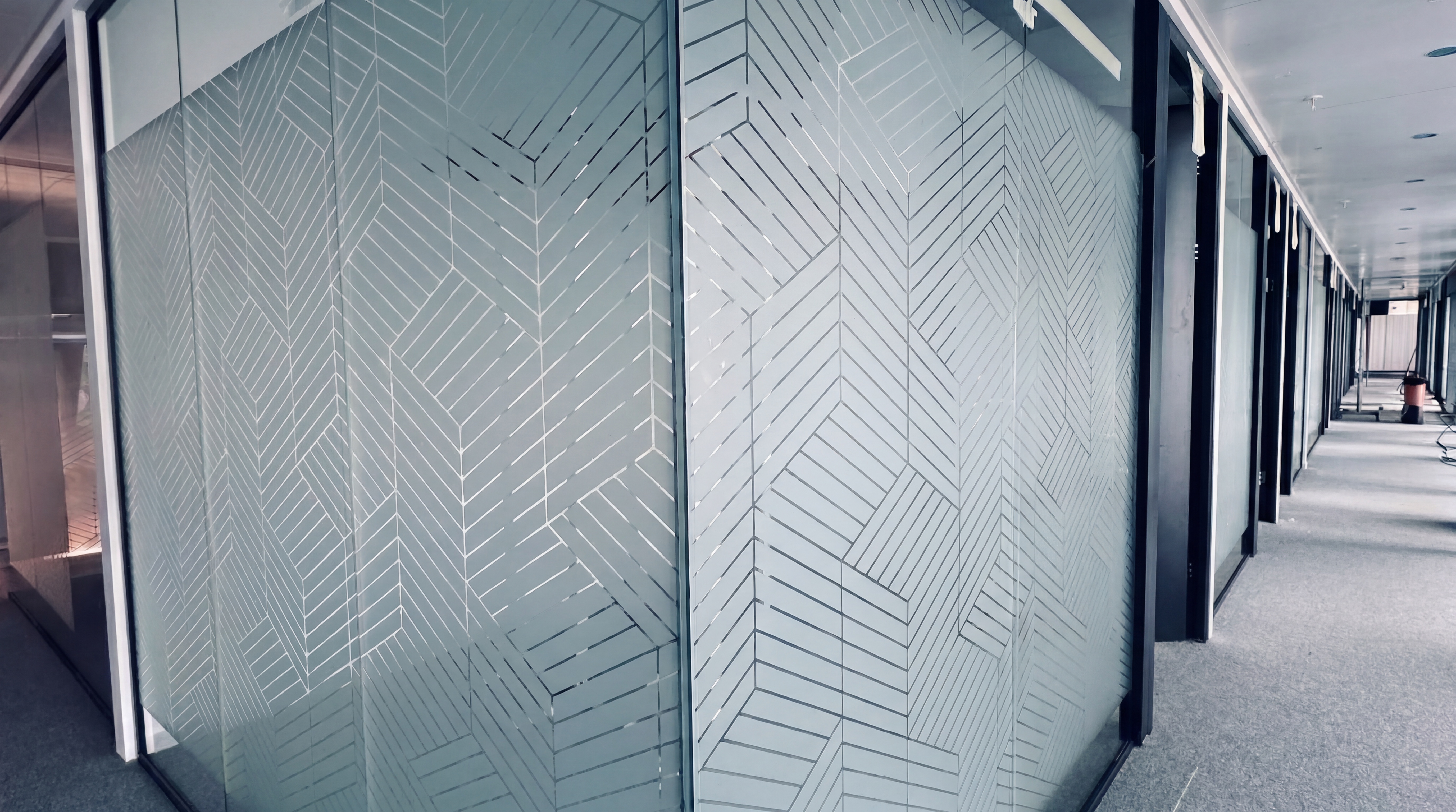 Cloison vitrée avec film dépoli motif géométrique chevrons — HF Vitro vitrophanie professionnelle Suisse romande
